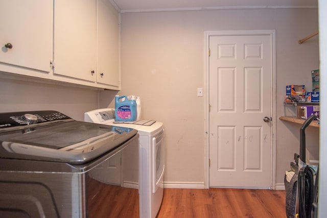 503 W College St, Rising Star, TX 76471 - washroom with light wood-type flooring, baseboards, ornamental molding, washing machine and dryer, and cabinet space