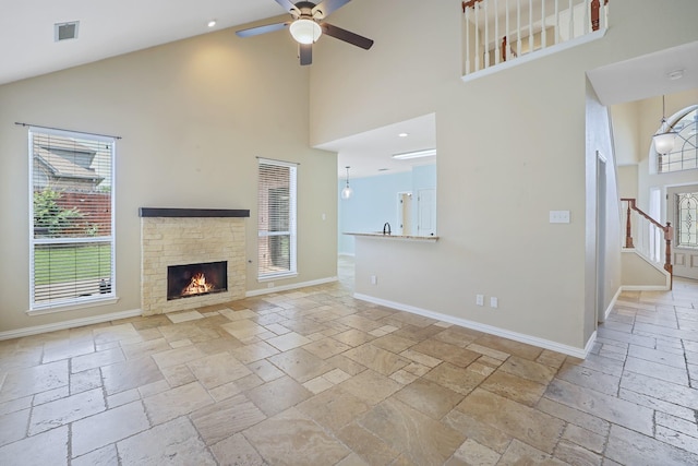 2313 Suntree, Flower Mound, TX 75022 - unfurnished living room featuring high vaulted ceiling, stone tile floors, ceiling fan, a fireplace, and baseboards