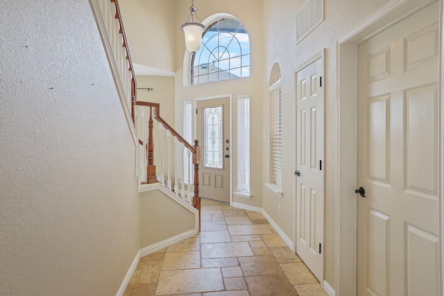 2313 Suntree, Flower Mound, TX 75022 - entryway featuring stone tile flooring, stairway, baseboards, and a high ceiling