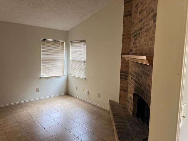 unfurnished living room featuring tile patterned flooring, a brick fireplace, a textured ceiling, and vaulted ceiling