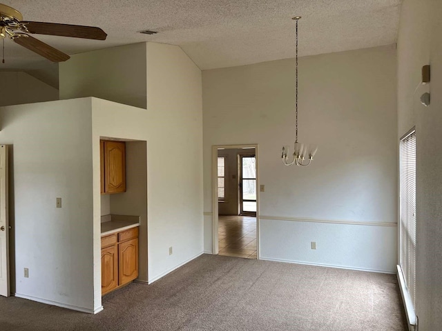 interior space with dark colored carpet, baseboards, a textured ceiling, high vaulted ceiling, and ceiling fan with notable chandelier