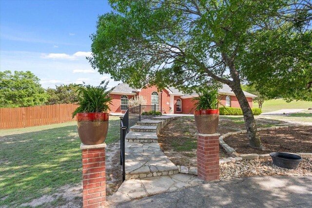view of front of house with fence and a front lawn