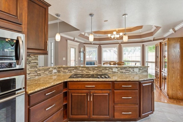 kitchen featuring crown molding, appliances with stainless steel finishes, decorative backsplash, and a peninsula