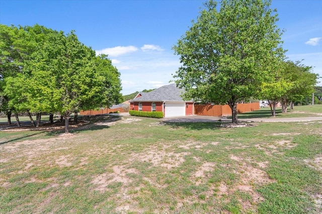 view of yard featuring fence and a garage