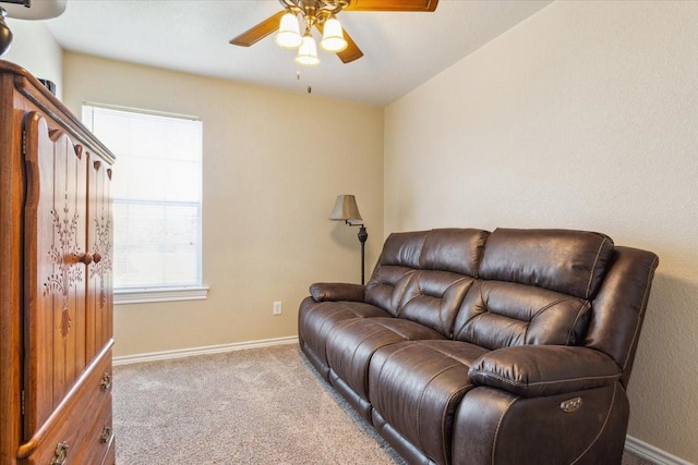 carpeted living room with baseboards and a ceiling fan