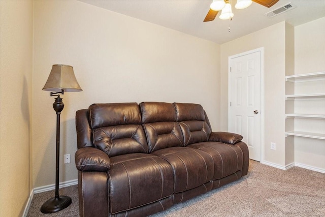 carpeted living room featuring visible vents, baseboards, and ceiling fan