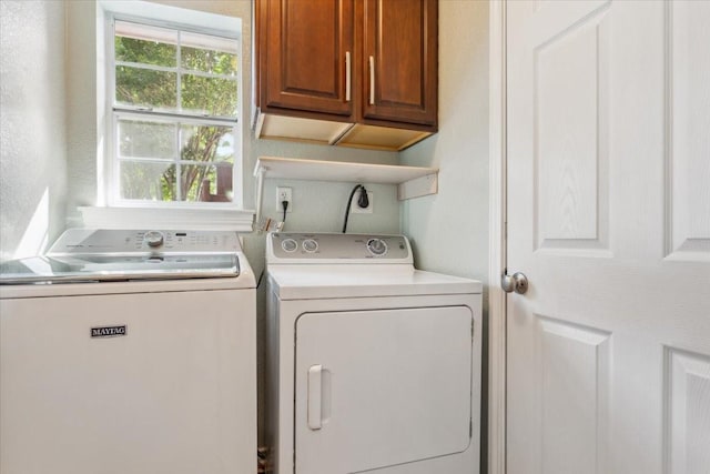laundry room featuring separate washer and dryer and cabinet space
