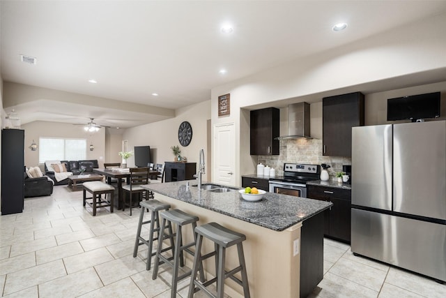 500 Harding Ln, Lavon, TX 75166 - kitchen featuring appliances with stainless steel finishes, wall chimney range hood, a sink, a breakfast bar area, and a kitchen island with sink