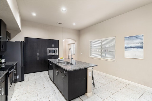 500 Harding Ln, Lavon, TX 75166 - kitchen with a sink, appliances with stainless steel finishes, arched walkways, dark cabinets, and an island with sink