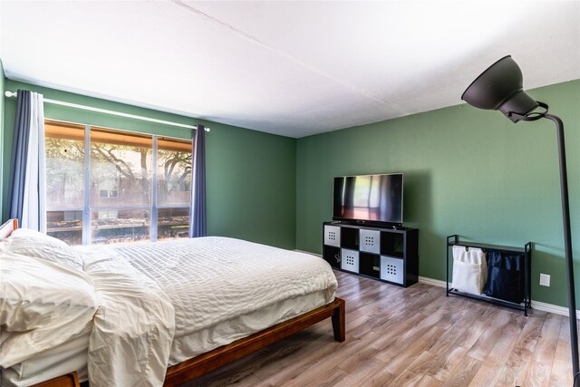 bedroom featuring baseboards and wood finished floors