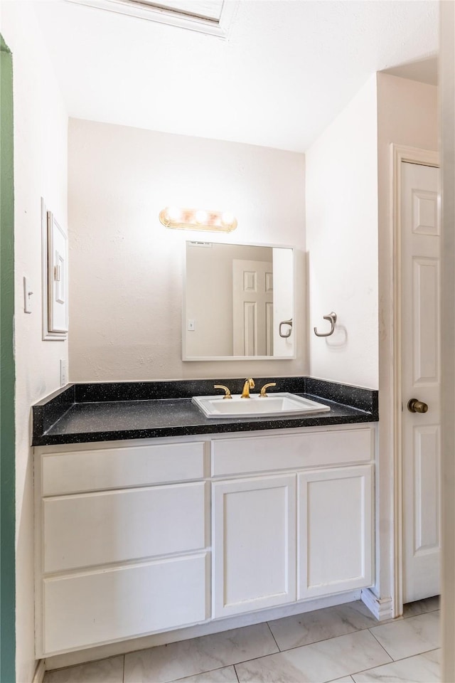 bathroom featuring marble finish floor and vanity