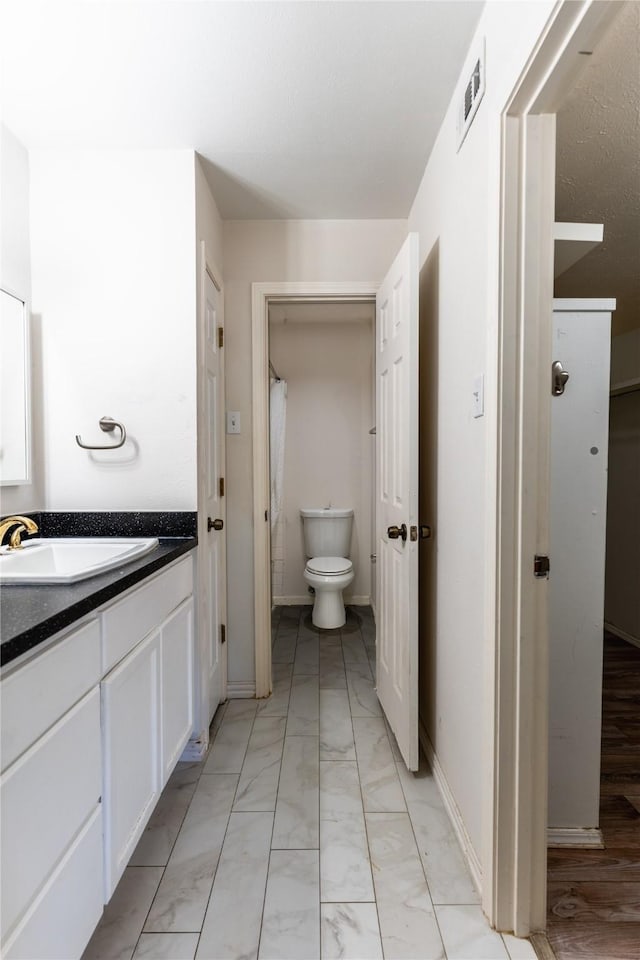 bathroom with visible vents, toilet, marble finish floor, and vanity