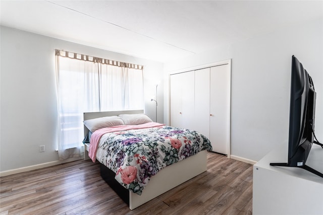 bedroom with a closet, baseboards, and wood finished floors