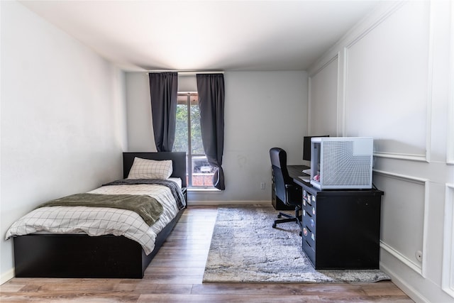 bedroom featuring wood finished floors and baseboards
