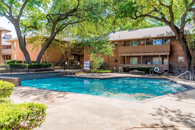 community pool featuring a patio area and fence
