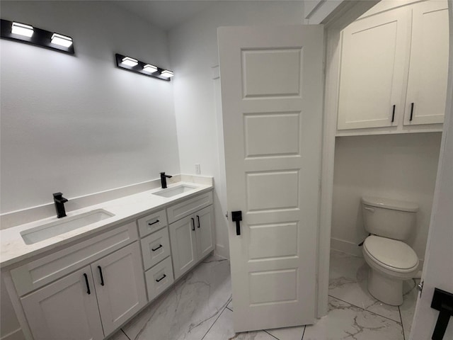 bathroom featuring a sink, toilet, double vanity, and marble finish floor