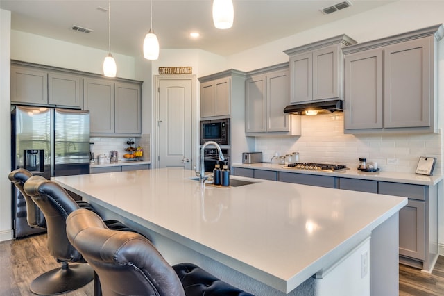 kitchen featuring gray cabinetry, visible vents, a sink, and appliances with stainless steel finishes