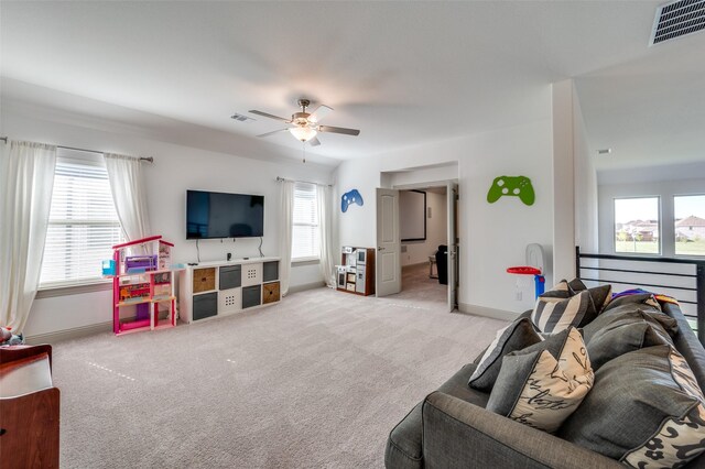 carpeted living area with visible vents, baseboards, and a ceiling fan