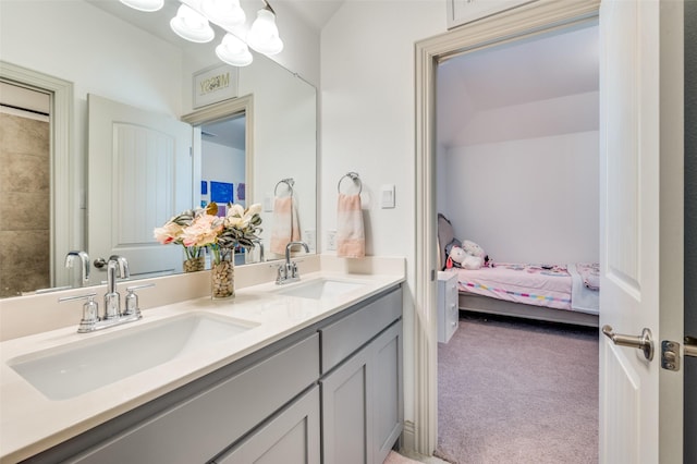 bathroom featuring double vanity, a sink, and connected bathroom