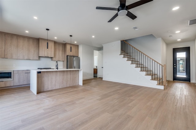 7312 Flyers Way, Dallas, TX 75235 - kitchen featuring modern cabinets, freestanding refrigerator, light brown cabinetry, light countertops, and a center island with sink