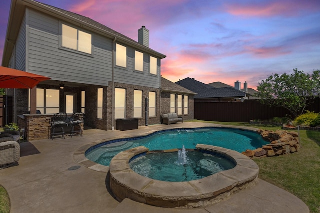 view of swimming pool featuring a patio, a pool with connected hot tub, outdoor dry bar, and fence