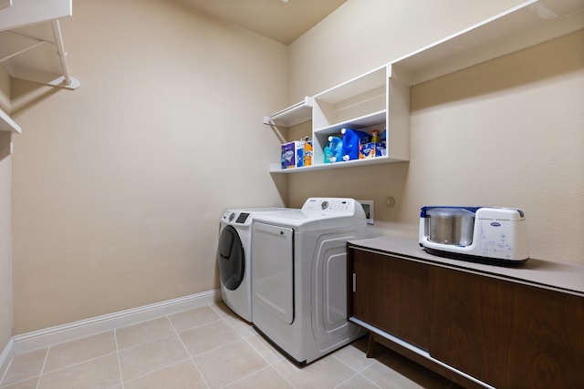 laundry room featuring laundry area, separate washer and dryer, light tile patterned floors, and baseboards