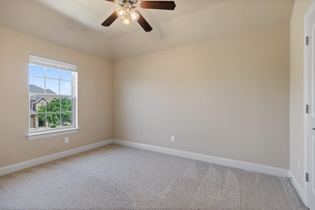 empty room featuring carpet, baseboards, vaulted ceiling, and ceiling fan