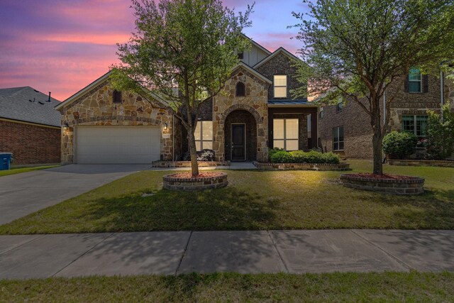 traditional home with concrete driveway, a front yard, stone siding, and an attached garage
