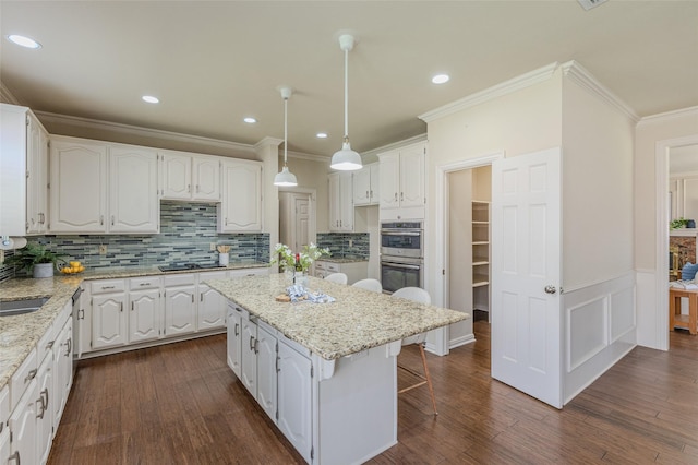 kitchen with white cabinetry, a center island, black cooktop, and double oven
