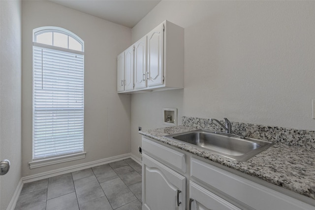 clothes washing area featuring hookup for an electric dryer, cabinet space, a sink, washer hookup, and baseboards