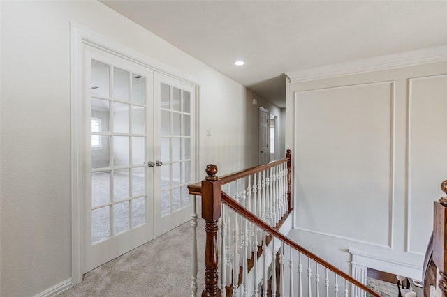 hallway featuring an upstairs landing, carpet flooring, french doors, and baseboards