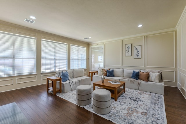 living room featuring a decorative wall, a healthy amount of sunlight, crown molding, and visible vents