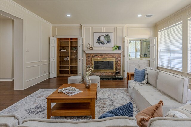 living area with recessed lighting, wood finished floors, a decorative wall, a premium fireplace, and visible vents