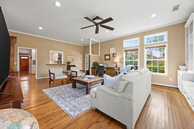 living room with baseboards, crown molding, light wood finished floors, and visible vents