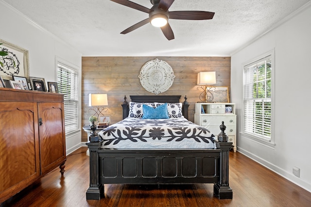 bedroom with wood finished floors, baseboards, and multiple windows