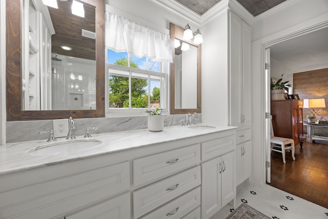 full bath with walk in shower, a sink, double vanity, and crown molding