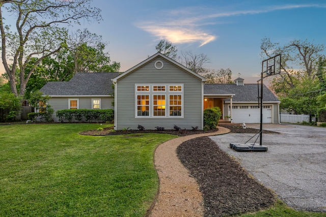 single story home with fence, an attached garage, aphalt driveway, and a front yard