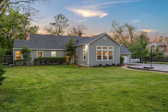 ranch-style home featuring fence, a yard, and a garage