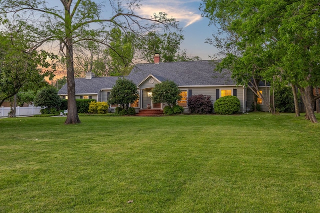 single story home with a chimney, fence, roof with shingles, and a front yard