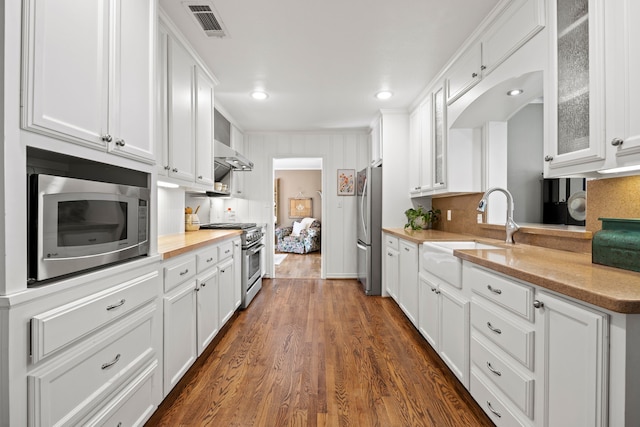 kitchen featuring white cabinets, visible vents, stainless steel appliances, and a sink