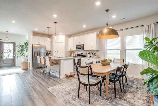 dining area featuring light wood-style floors, baseboards, visible vents, and recessed lighting
