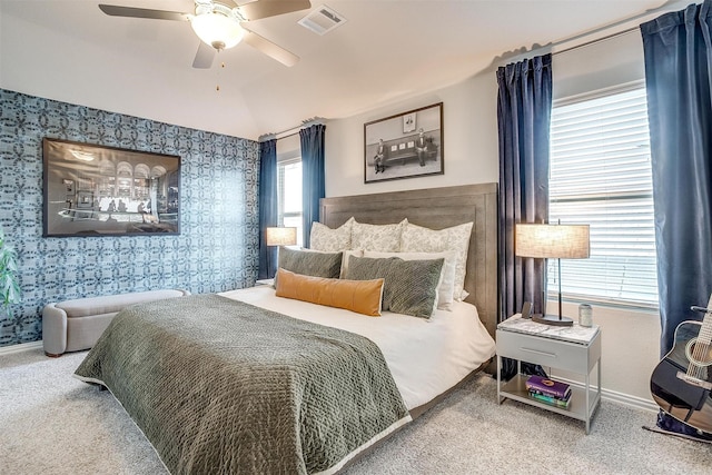 bedroom with baseboards, wallpapered walls, a ceiling fan, carpet floors, and visible vents