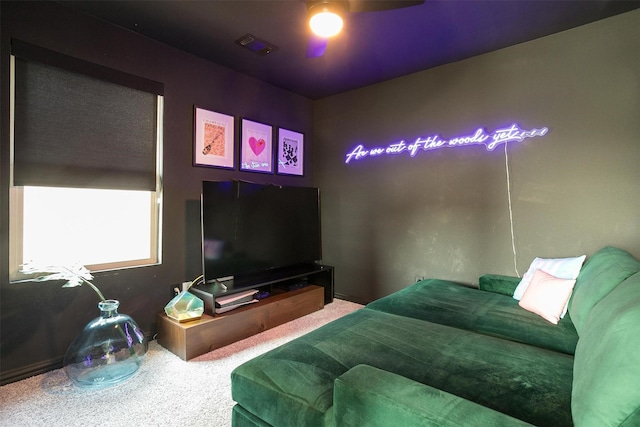 carpeted living area with visible vents and ceiling fan