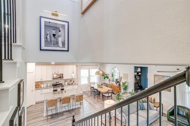 interior space featuring a towering ceiling and wood finished floors