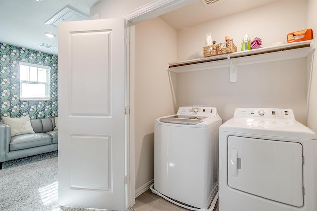 washroom featuring visible vents, baseboards, washer and dryer, and laundry area