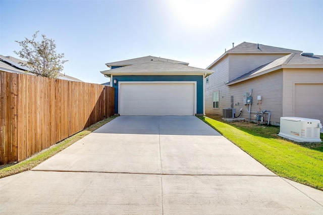 view of side of home with concrete driveway, cooling unit, a garage, fence, and a lawn