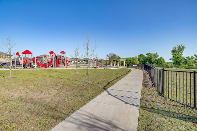 communal playground featuring fence and a lawn