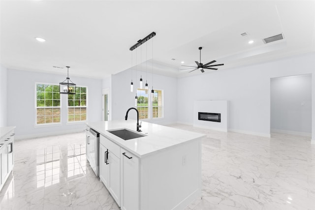 kitchen featuring recessed lighting, white cabinets, dishwasher, marble finish floor, and a sink