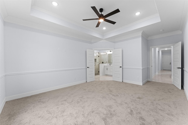 unfurnished bedroom with baseboards, crown molding, a tray ceiling, recessed lighting, and light carpet