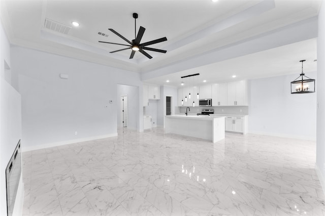unfurnished living room with recessed lighting, visible vents, a tray ceiling, and ornamental molding
